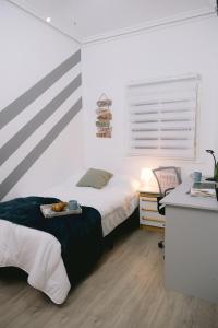 a bedroom with a bed and a table with a tray on it at Piso compartido Delyrent, SFJ in Jaén