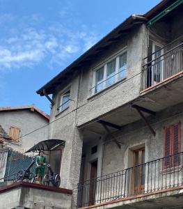 Un hombre parado en un balcón con una bicicleta en un edificio. en Casa CINZIA, en Bellagio 40 fotos más