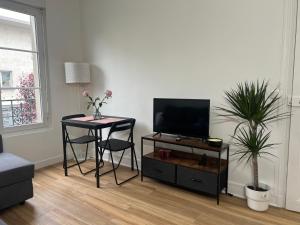 a living room with a table and a tv and a table and chairs at Modern Renovated Apartment -15 min Orly airport in Viry-Châtillon