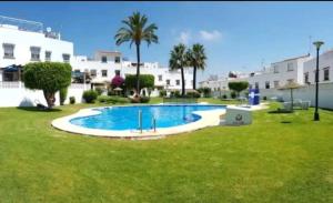 a pool in a yard with palm trees and buildings at Benyamina House in Torremolinos