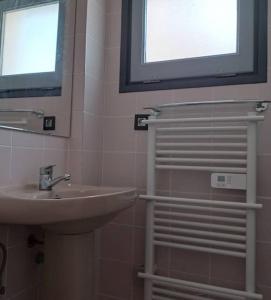 a bathroom with a sink and a mirror and a window at Appartement port Nautic 5 Empuria in Empuriabrava +17 photos