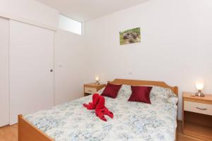 a bedroom with a bed with a red stuffed animal on it at Charming Apartment in Dubrovnik | 40 m² | Parking Included in Dubrovnik