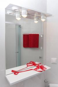 a mirror with a red box and red ribbon on a counter at Charming Apartment in Dubrovnik | 40 m² | Parking Included in Dubrovnik +14 photos