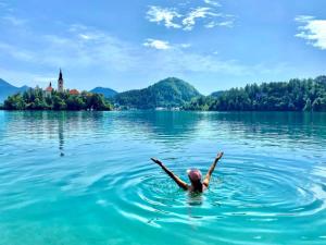 a woman swimming in the water in front of a castle at Tree in Bled +63 photos