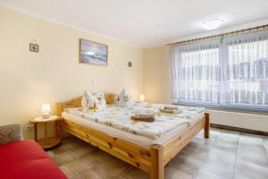 1 dormitorio con cama grande de madera frente a una ventana en Caeser - Ferienwohnungen Zinnowitz, en Zinnowitz