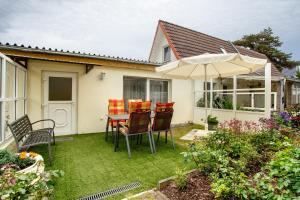 Un patio con una mesa y sillas y una sombrilla. en Caeser - Ferienwohnungen Zinnowitz, en Zinnowitz