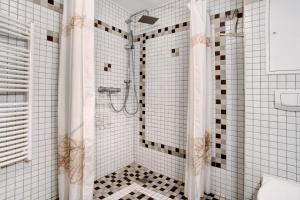y baño con ducha y azulejos blancos y negros. en Caeser - Ferienwohnungen Zinnowitz, en Zinnowitz 13 fotos más