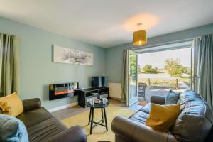 a living room with a couch and a tv at Blackaddie House Hotel in Sanquhar