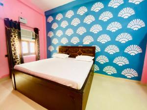 a bedroom with a bed with a blue and white wall at The Narayan Bhawan , ramanuj ashram ,haridas nagar ,ramkot ayodhya ji in Ayodhya