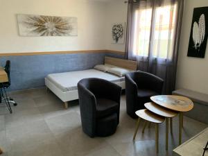 pokój z łóżkiem, dwoma krzesłami i stołem w obiekcie Grand studio très agréable avec bar, cuisine et terrasse w Cagnes-sur-Mer