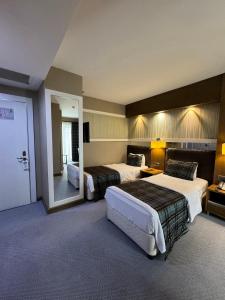 una camera d'albergo con due letti e uno specchio di Grand Hotel Van a Van