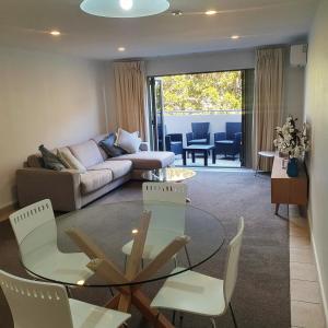 a living room with a couch and a table and chairs at Midtown Tui Villa - Taupō Central Holiday Unit in Taupo