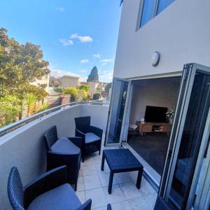 a balcony with chairs and a television on a building at Midtown Tui Villa - Taupō Central Holiday Unit in Taupo