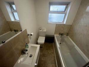 a bathroom with a tub and a toilet and a sink at The London Inn in Cheltenham