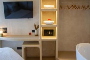 a room with a desk and a tv on a wall at Hotel Galfi - Boutique & Adults Only in San Antonio