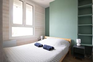 a bedroom with a bed with two blue pillows on it at T3 en duplex hyper centre de Bourg en Bresse in Bourg-en-Bresse
