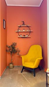 uma cadeira amarela num quarto com uma parede laranja em Modern & Cozy 51sqm Apt in Thisseio em Atenas