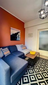 uma sala de estar com um sofá azul e uma mesa em Modern & Cozy 51sqm Apt in Thisseio em Atenas