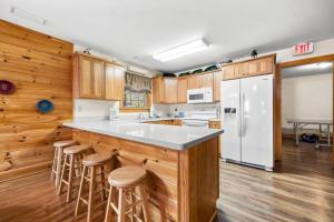 una cucina con mobili in legno e un frigorifero bianco di Poplar Point Condo Unit 12D by Eden Crest a Pigeon Forge