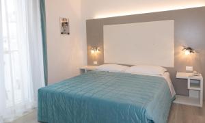 sypialnia z łóżkiem z niebieską kołdrą w obiekcie Hotel & Aparthotel Carinthia S w mieście Lido di Jesolo