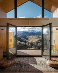 an open glass door with a view of mountains at Amont Chalet in Peştera