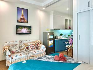 a living room with a couch and a kitchen at Deluxe Studio Next National Convention Centre And Marriott Hotel in Hanoi