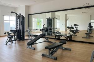 une salle de sport avec un grand miroir et des rangées de vélos d'exercice dans l'établissement Taiping Sunset View Penthouse Homestay near Lake Garden, à Taiping