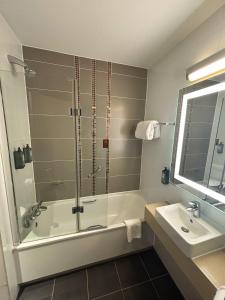La salle de bains est pourvue d'une douche, d'une baignoire et d'un lavabo. dans l'établissement Clayton Hotel Cardiff, à Cardiff