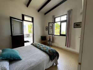 una camera da letto con un letto e due finestre di Le jardin des B-joux a Le Morne-Vert
