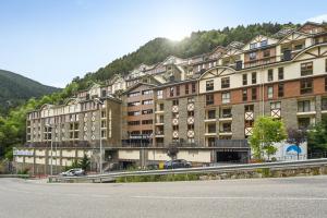 a large building with a mountain in the background at Studio at Arinsal 100 m away from the slopes with wifi in Arinsal