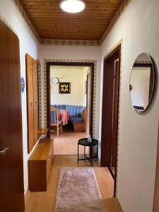 einen Flur mit einem Wohnzimmer und einem Spiegel in der Unterkunft Wohlfühloase Niklasdorf in Niklasdorf + 4 Fotos