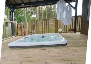a jacuzzi tub sitting on a deck at Hollicarrs - Wildflower Lodge in York