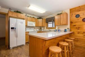 a kitchen with a white refrigerator and wooden cabinets at Briarstone Lodge Condo 13C in Pigeon Forge +26 photos