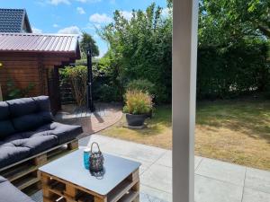 a patio with a couch and a coffee table at Ferienhaus Norderpiep 54 in Friedrichskoog