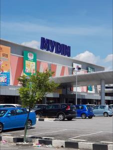 ein Einkaufszentrum mit Autos auf einem Parkplatz in der Unterkunft Sutera Cottage, Best Place for Your Short Getaway in Sungai Petani