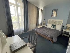 1 dormitorio con 1 cama y escritorio con ordenador portátil en Hotel De France en Perpiñán