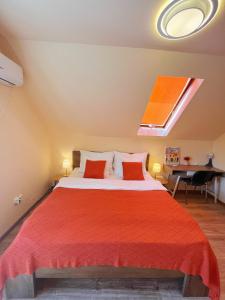 um quarto com uma cama grande e lençóis vermelhos em Garden villa em Budapeste