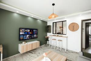 a living room with a tv on a green wall at Royale Lumineux Jacuzzi Parking privé in Mulhouse