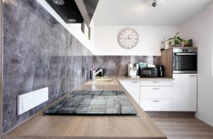 a kitchen with a counter with a clock on the wall at FERIENHAUS AyNa, direkt an der Schweizer Grenze in Bad Säckingen