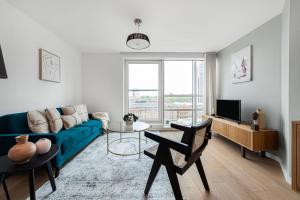 a living room with a blue couch and a tv at The Lambeth Apartment in London