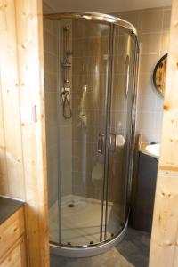 una doccia con porta in vetro in bagno di PenichePraia - Bungalows, Campers & SPA a Peniche
