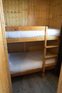 PenichePraia - Bungalows, Campers & SPA في بينيش: سريرين بطابقين في غرفة خشبية