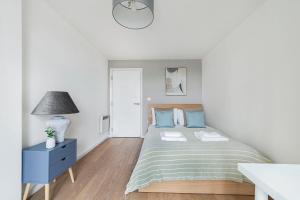 a white bedroom with a bed and a blue nightstand at The Lambeth Apartment in London