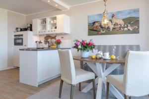a kitchen and dining room with a table and chairs at Hyggelig in Westerland +18 photos