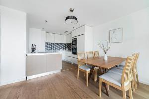 a kitchen and dining room with a wooden table and chairs at The Lambeth Apartment in London