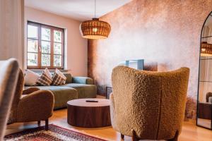 uma sala de estar com um sofá, cadeiras e uma mesa em Schmidtburger Hof em Weiler