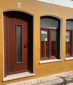 a building with three windows and a door at Casas Dona Zi in Vila Nova de Milfontes