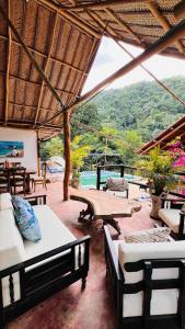 a patio with beds and tables and a view of the water at Minca cabaña la roca in Santa Marta