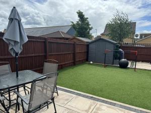 a backyard with a ping pong ball and a fence at 4 Bed House - Sleeps 8 - HotTub - Garden - Parking in Milton Keynes