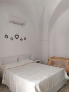 una camera bianca con un letto e una parete bianca di Casina nel Salento a Lecce